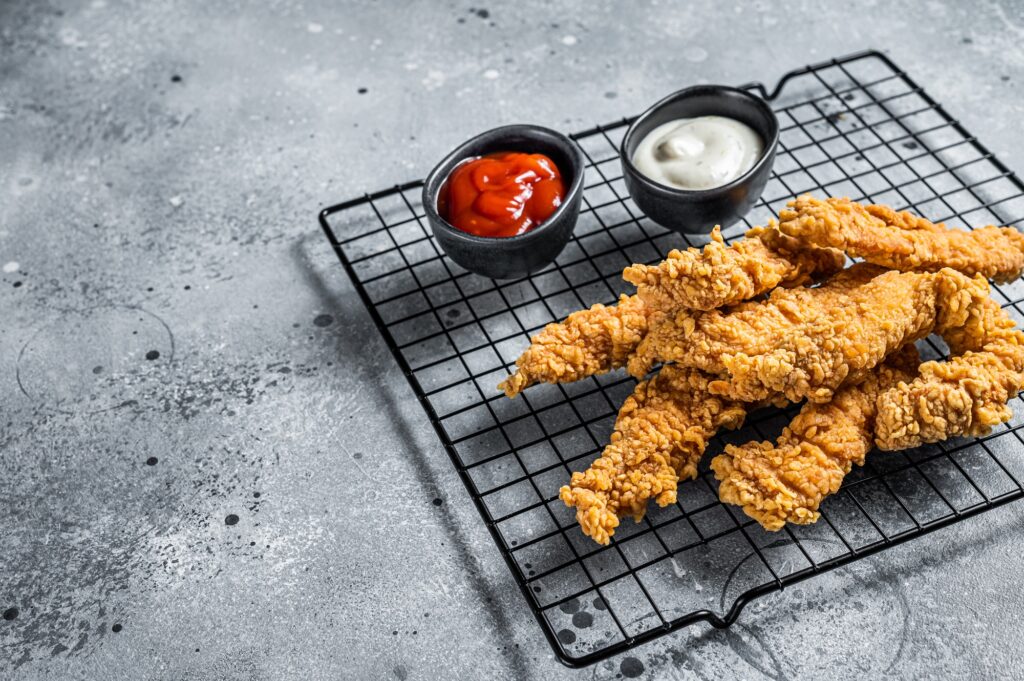 Dip fried Chicken Steak Fingers strips with sauces. Gray background. Top view. Copy space